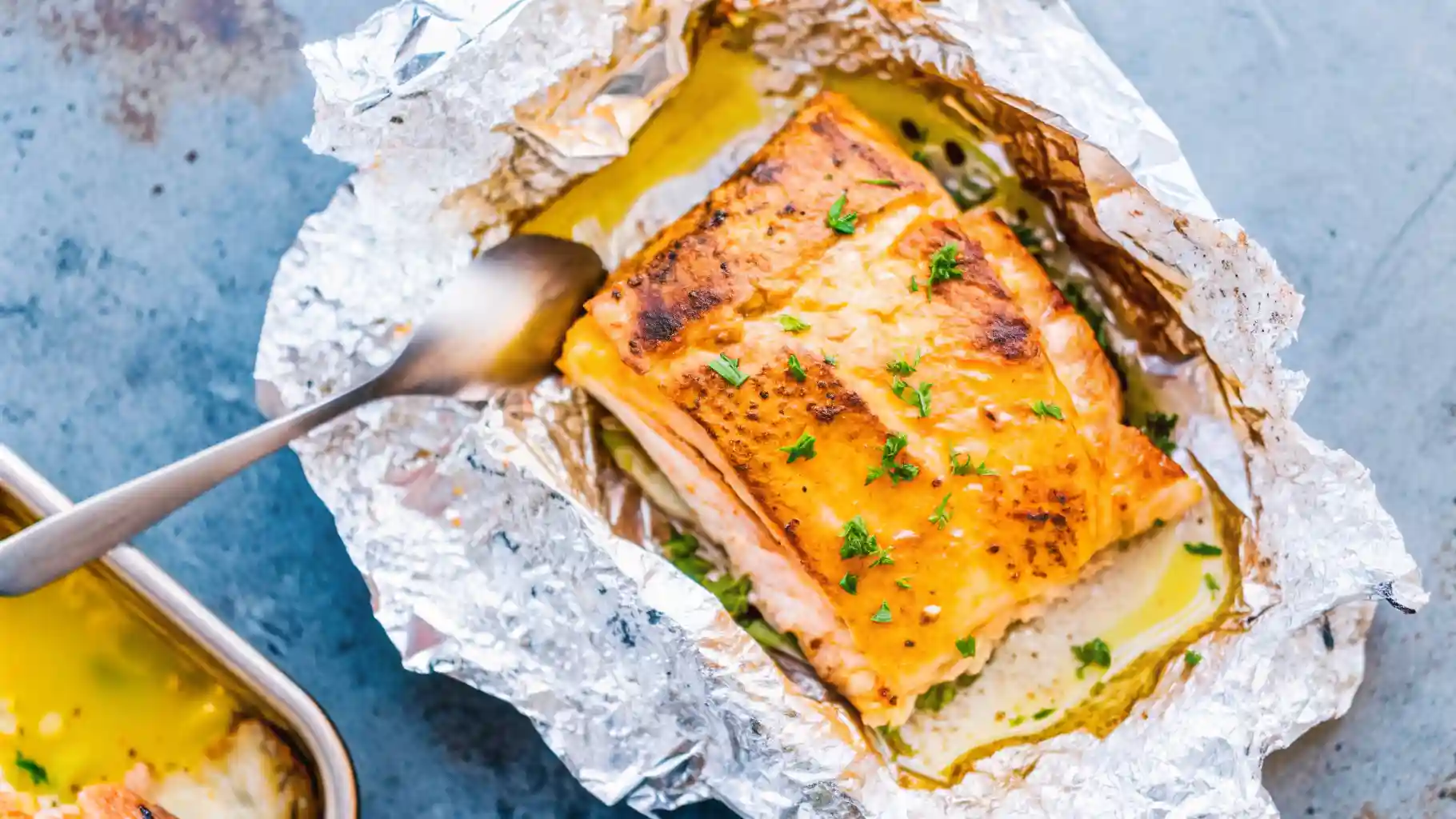 Overhead close-up of Sheet Pan Lemon Garlic Butter Salmon: tender salmon steaks baked to perfection with bright lemon wedges, melted garlic butter drizzle, fresh veggies, and parsley garnish—simple 20-minute sheet pan magic.
