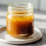 Five minute Asian salad dressing with sesame oil, rice vinegar, soy sauce, honey, and fresh ginger in glass jar