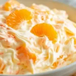 Mandarin orange jello salad with cottage cheese, Cool Whip, mini marshmallows, crushed pineapple, and orange gelatin