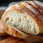 3 ingredient artisan bread crusty chewy golden boule with flour-dusted cracked crust, three cups bread flour, instant yeast, and kosher salt baked in Dutch oven at 450°F