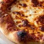 Artisan pizza dough with high hydration long fermentation method - 500g 00 flour or all-purpose flour combined with 375g warm water divided autolyse 20 minutes, quarter teaspoon active dry yeast dissolved reserved tablespoon water, 1¾ teaspoons fine sea salt added and incorporated via stretch-and-fold technique, bulk fermented 5-6 hours room temperature until doubled, divided shaped dough balls refrigerated 24-72 hours cold fermentation developing deep complex flavor - stretched 12-inch circle baked pizza steel or stone 500-550°F