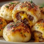 Garlic Parmesan cheeseburger bombs with one pound ground beef browned with two cloves minced garlic, drained, then mixed with one cup shredded cheddar cheese cubed for epic cheese pulls, half cup freshly grated Parmesan, salt, pepper, and one teaspoon each garlic powder and onion powder - scooped into eight flattened circles of 16.3-ounce refrigerated flaky biscuit dough, wrapped and sealed seam-side down, brushed generously with two tablespoons melted butter mixed with extra Parmesan, and baked at 375°F for 12-15 minutes until deeply golden