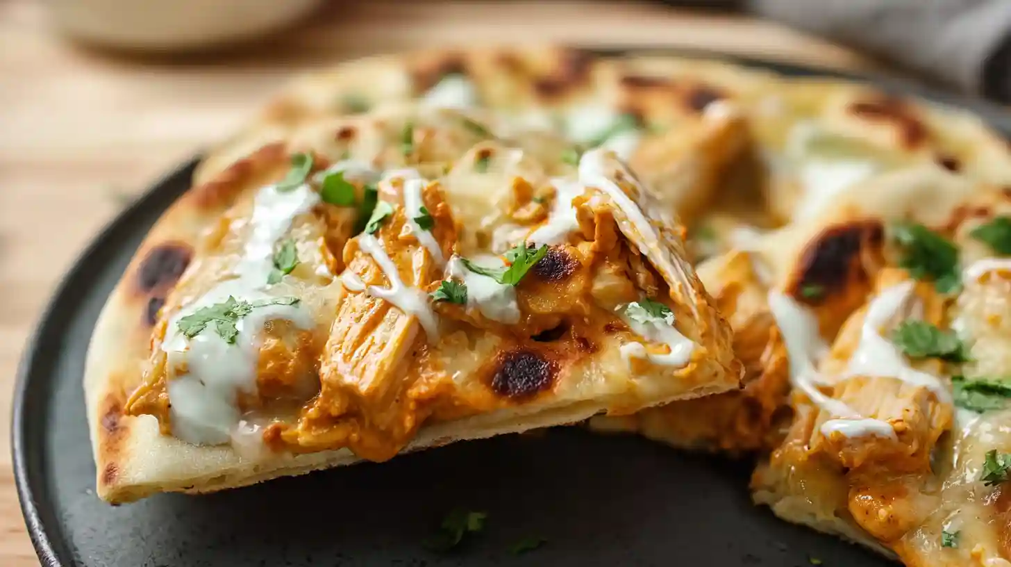Homemade flatbread with creamy butter chicken, melted mozzarella cheese, fresh cilantro and spiced tomato sauce
