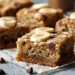 Moist banana bread blondies with ripe bananas brown butter chocolate chips and walnuts cut into thick fudgy squares